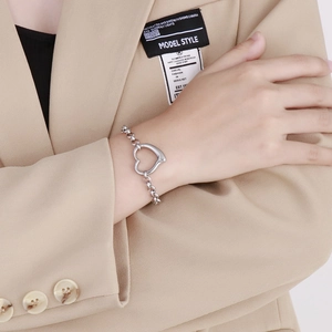 Dettaglio del bracciale a catena in argento 925 con ciondolo a cuore indossato al polso
