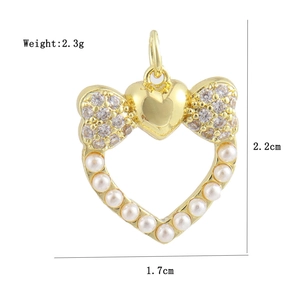 Macro shot of 18K gold plated heart bow pendant with clear zircons and white pearls