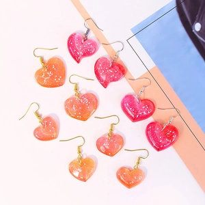 DIY heart-shaped resin earrings in vibrant colors with glitter finish and metal hooks