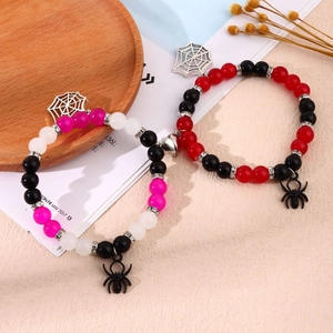 Close-up of magnetic couple bracelets with spider charms and colorful beads for Halloween