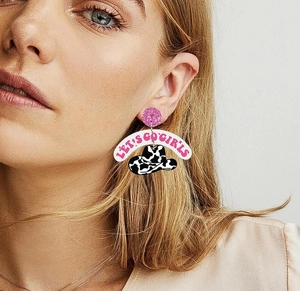 Close-up of acrylic cowboy hat earrings with Let's Go Girls text on a female model