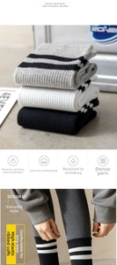 Detail of ribbed knit cotton crew socks featuring classic athletic stripes on the cuff
