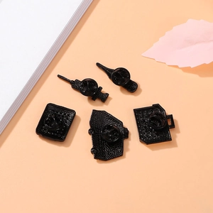 Set of five metal medical pins showing black rubber clutch backs on a pink background