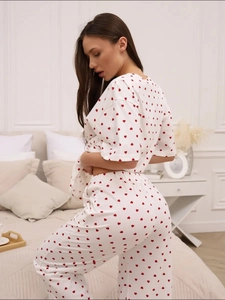 Detail of the draped white pajama set with all-over red heart print from a side-back view