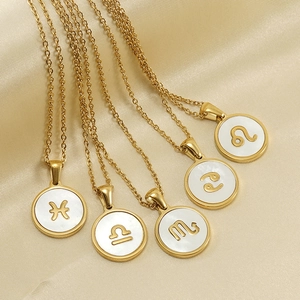 Golden stainless steel zodiac necklaces with circular shell pendants on beige satin