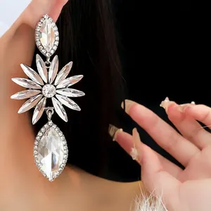 Elegant silver flower drop earrings with marquise crystals on a model