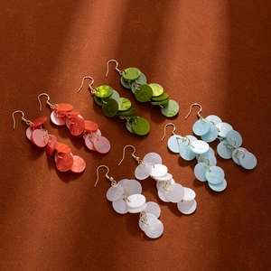 Detail of colorful layered round resin drop earrings in red, green, blue and white