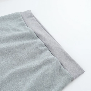 Détail du tissu en maille gris clair avec bord-côte élastique sur le sweat décontracté