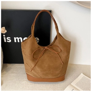 Detailed view of brown suede tote bag with leather straps and decorative bow knot detail