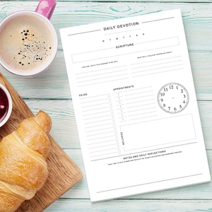 Daily devotion planner showing prayer sections and to-do list on light wood background