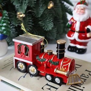 Festive red Christmas train ornament with gold accents on vintage books with decor