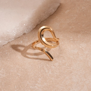 Detailed close-up of a golden fluid irregular open ring with a high-polished mirror finish
