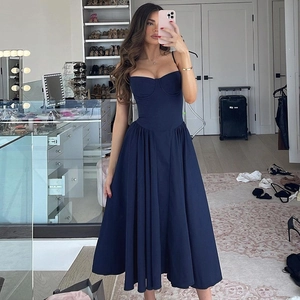 Detail view of navy blue pleated maxi dress featuring a slim waist and backless design