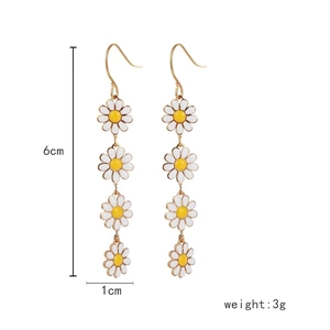 Detail view of 6cm long daisy drop earrings showing white petals and yellow centers