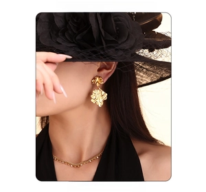 Details von goldenen Hammerschlag-Ohrringen und Diamantkette an Vintage-Model