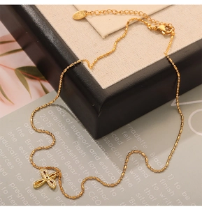 Detail of gold cross pendant necklace with inset crystals on a chic gift display card