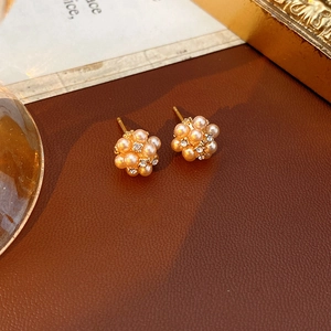 Détails des boucles d'oreilles fleurs avec perles et dorure sur cuir marron