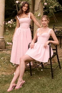 Detailed outdoor shot of pink gingham dresses with lace trim and side pockets