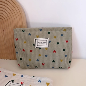 Green corduroy makeup bag with colorful heart embroidery and Time to Party label