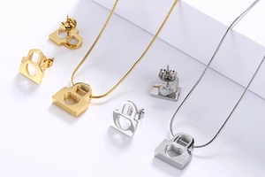 Macro shot of gold and silver hollow heart lock necklaces and stud earrings set