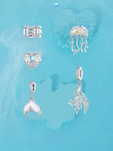 Macro shot of S925 sterling silver ocean charms with blue gems and mother of pearl