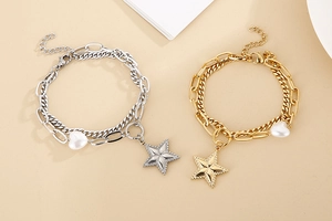 Detail of star and heart charm layered bracelet set in gold and silver finish