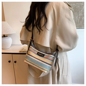 Detail of multi-colored striped woven texture with dark leather strap and metal buckle