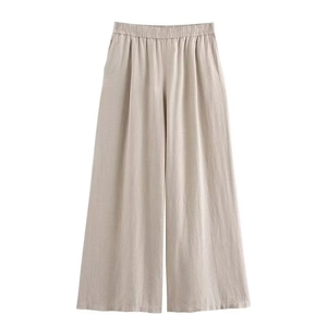Dettaglio dei pantaloni larghi in lino color avena con vita elastica e coulisse
