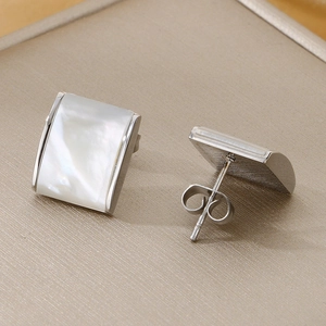 Macro view of square stainless steel stud earrings with iridescent white mother of pearl