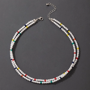 Detail of a double-layered pearl necklace with colorful beads and adjustable silver clasp