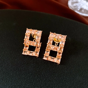 Vue détaillée de boucles d'oreilles carrées en zircon plaqué or avec double cadre ajouré