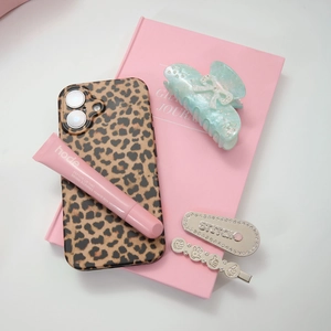 Flat lay of light green acetate bow hair claw clip with rhinestones and fashion items