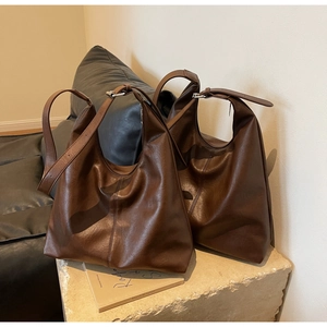 Detail showing the soft texture and large capacity of the dark brown leather tote bag