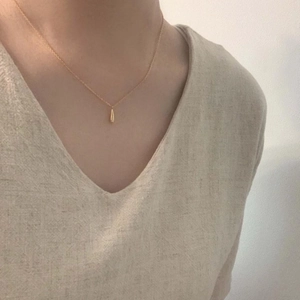 Minimalist 925 sterling silver gold plated teardrop pendant necklace worn by a model