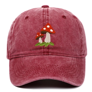Detailed view of mushroom embroidery and washed vintage cotton texture on burgundy cap