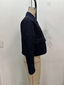 Detail view of navy blue quilted nylon jacket with corduroy collar on a mannequin
