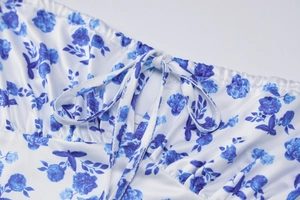 Detailed close-up of the ruffled neckline with tie-up strings on blue floral summer dress