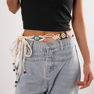 Detail of bohemian woven waist chain with blue stones and wooden beads on model