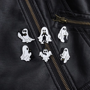 Detailed view of Halloween ghost and black cat enamel pins on black leather jacket
