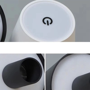 Close-up of portable bottle lamp top with power icon on black and white casing