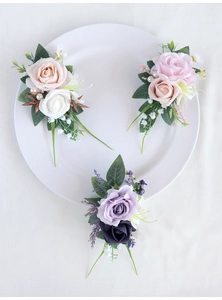 Flat lay of artificial boutonniere flowers in champagne, pink, and purple silk petals