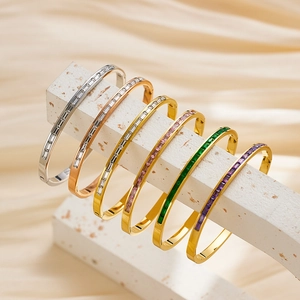Vintage stainless steel bangles with colorful rectangular crystals on stone display