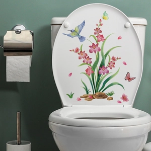 Close-up of toilet decal with pink flowers and a blue hummingbird on a white lid