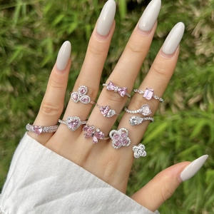 Close-up of S925 silver rings with pink heart and butterfly crystals on a hand