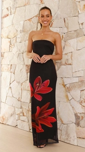 Gros plan d'imprimé floral rouge sur une robe bustier noire élégante avec mur de pierre