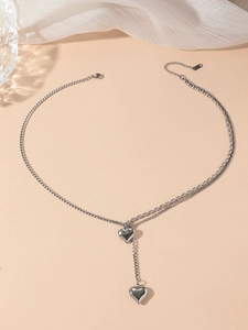 Detail of silver double-layered Y-necklace featuring polished heart pendants and steel chain