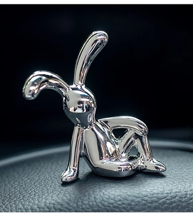 Nahaufnahme einer silbernen Hasenfigur mit reflektierendem Metallic-Finish auf Leder