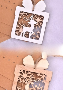 Detail of wooden Christmas reindeer gift tag with white laser cut snowflake patterns