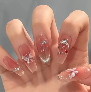 Details von rosa Ombré-Nägeln mit 3D-Silberschmetterlingen und funkelnden Kristallen