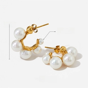 Detail of C-shaped gold pearl earrings with dimensions 24mm and weight 9g shown